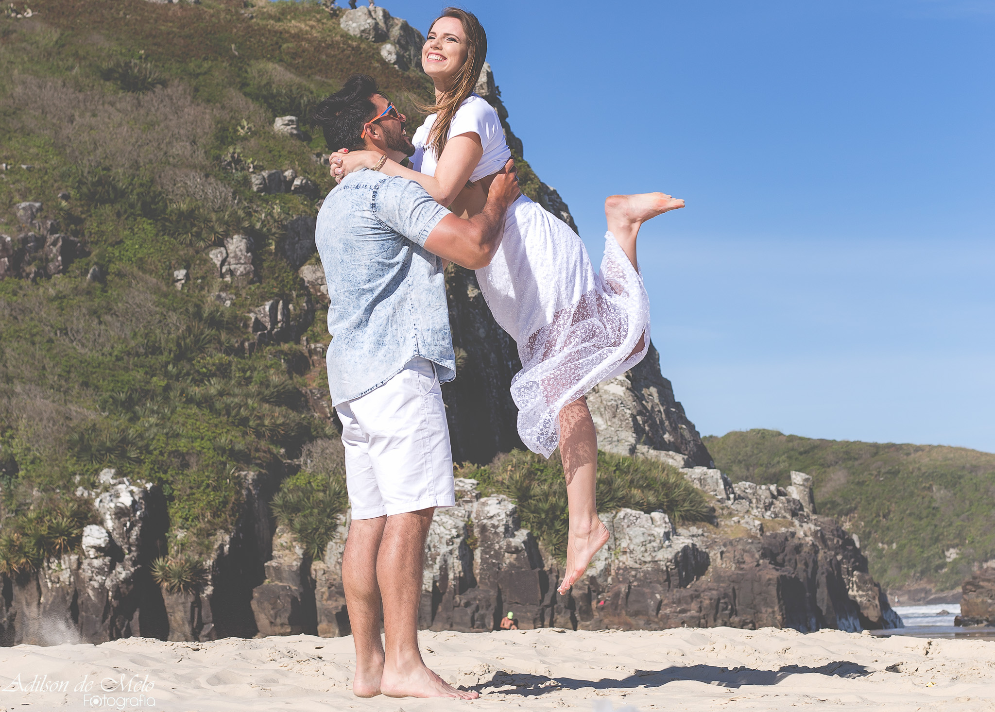 Ensaio pré casamento na praia, erguendo a noiva, clicado pelo fotógrafo Adilson de Melo na praia de Torres/RS