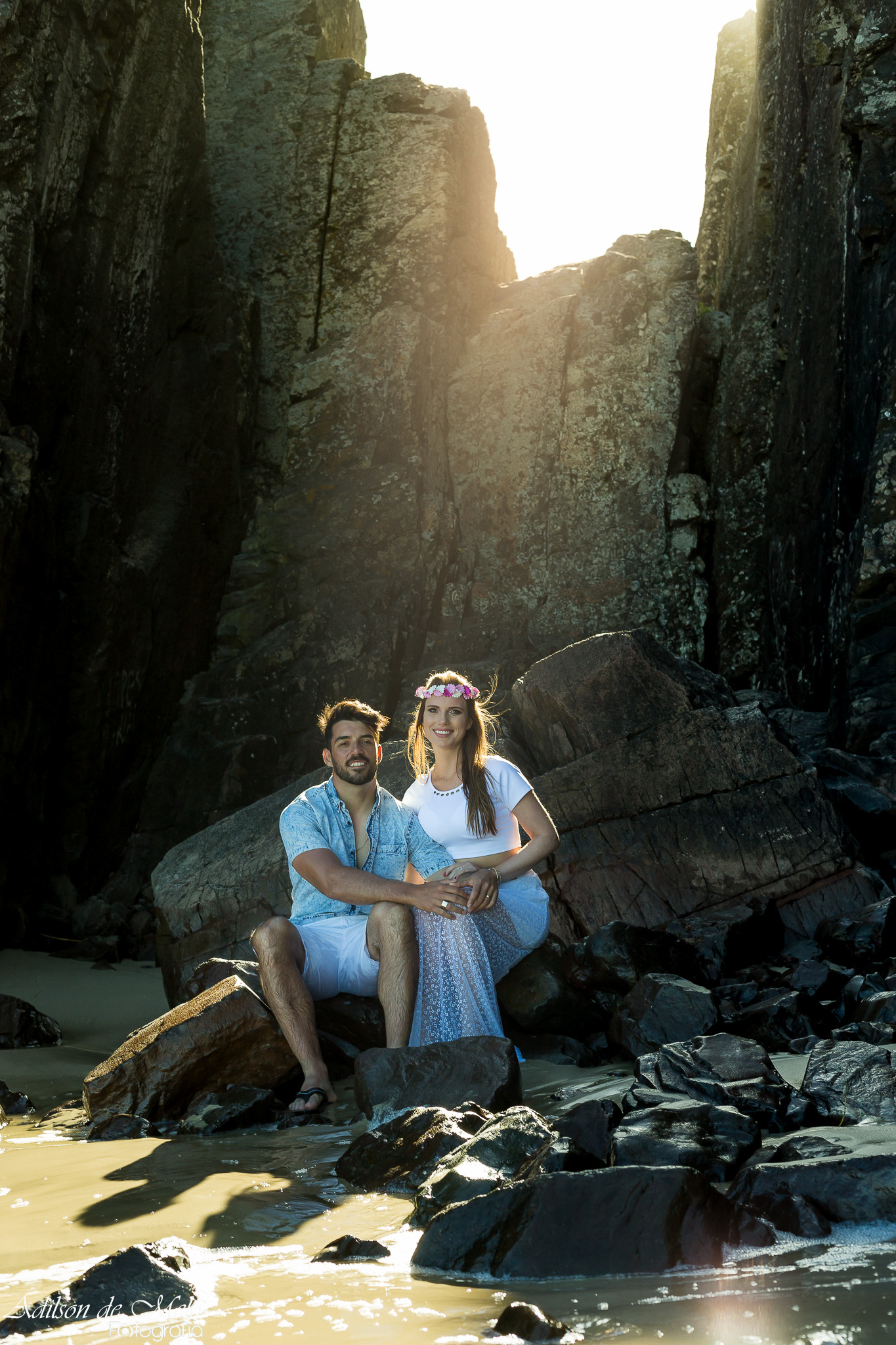 Ensaio pré casamento na praia, sentados nas rochas, clicado pelo fotógrafo Adilson de Melo na praia de Torres/RS