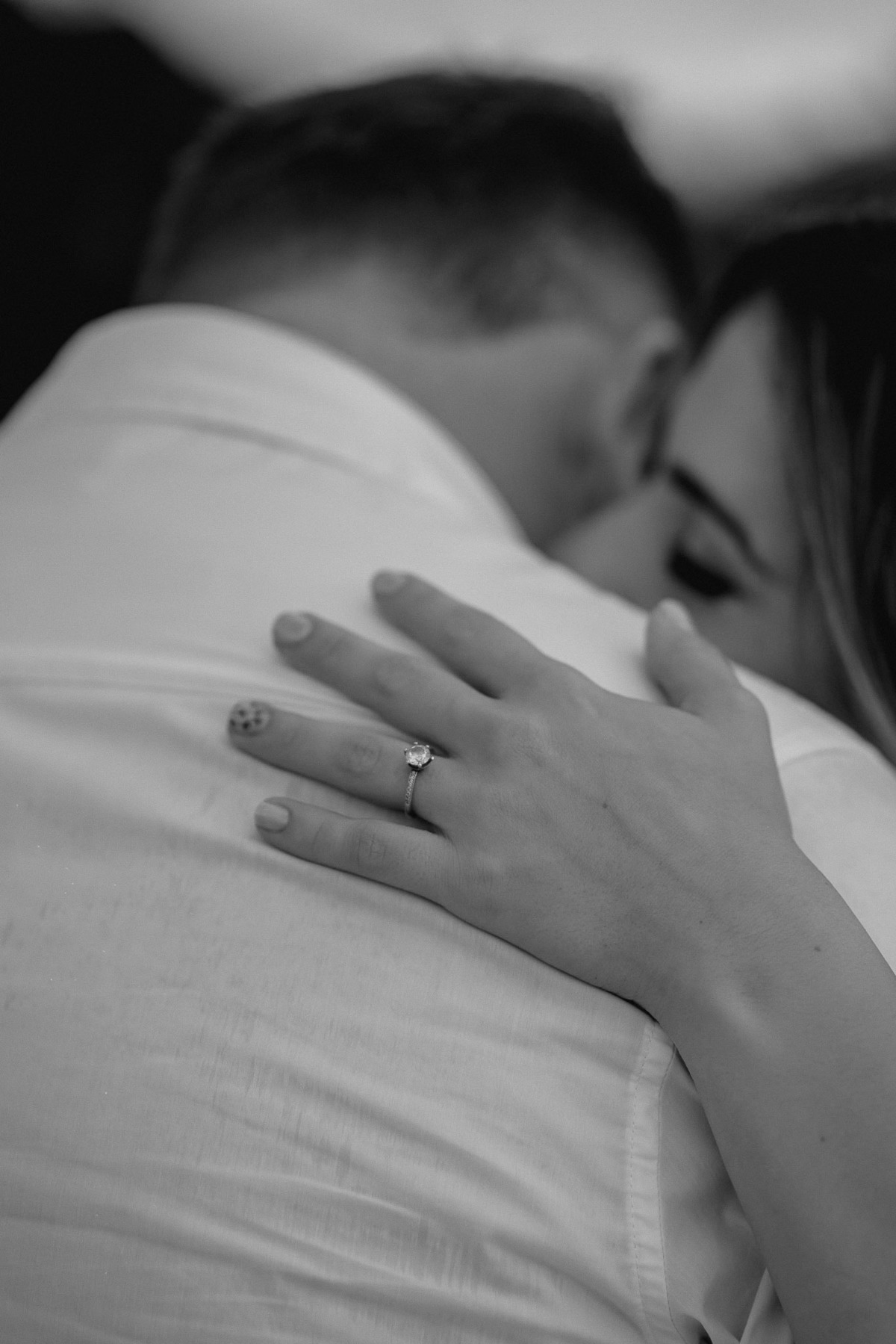 foto de pre-wedding. noiva abraçando noivo, mostrando o detalhe da aliança.