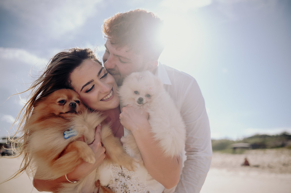 Foto de pré wedding feita com cachorro na praia. casal com cachorros super felizes. foto feita por javorski porducoes 