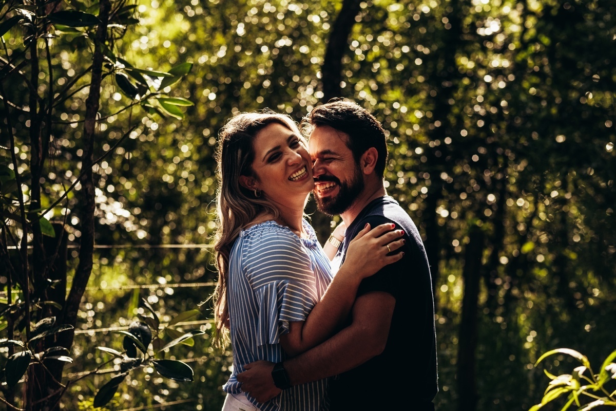 casal feliz sorrindo espontânea natureza árvores por do sol