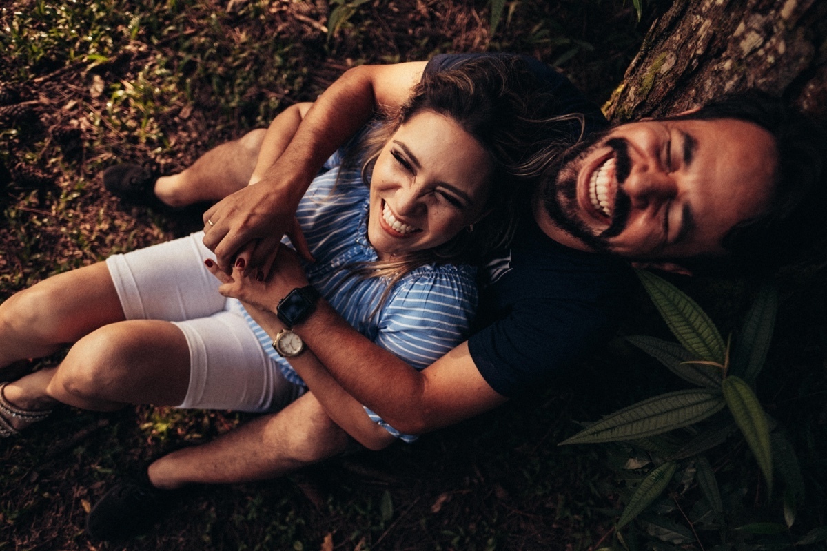 vista superior casal sentado árvore abraçado sorrindo intimista aconchego