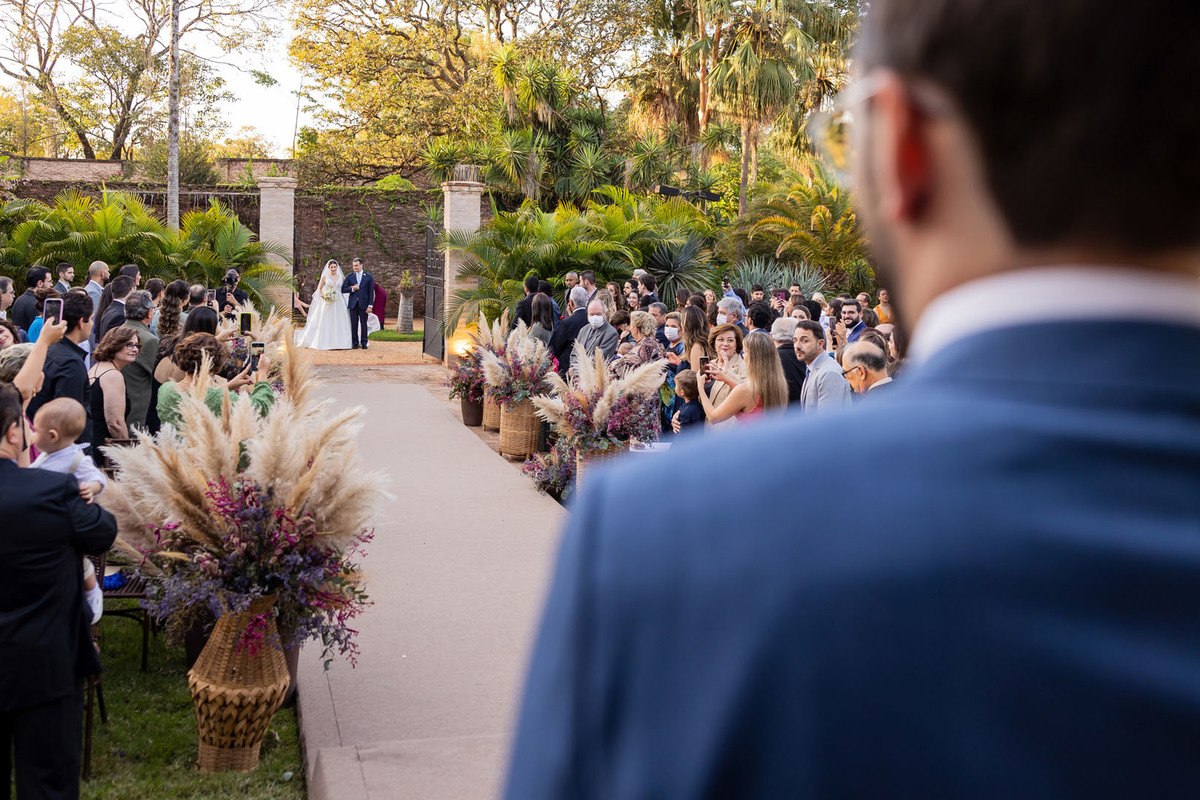 noivo no altar e noiva entrando na cerimonia na casa de campo