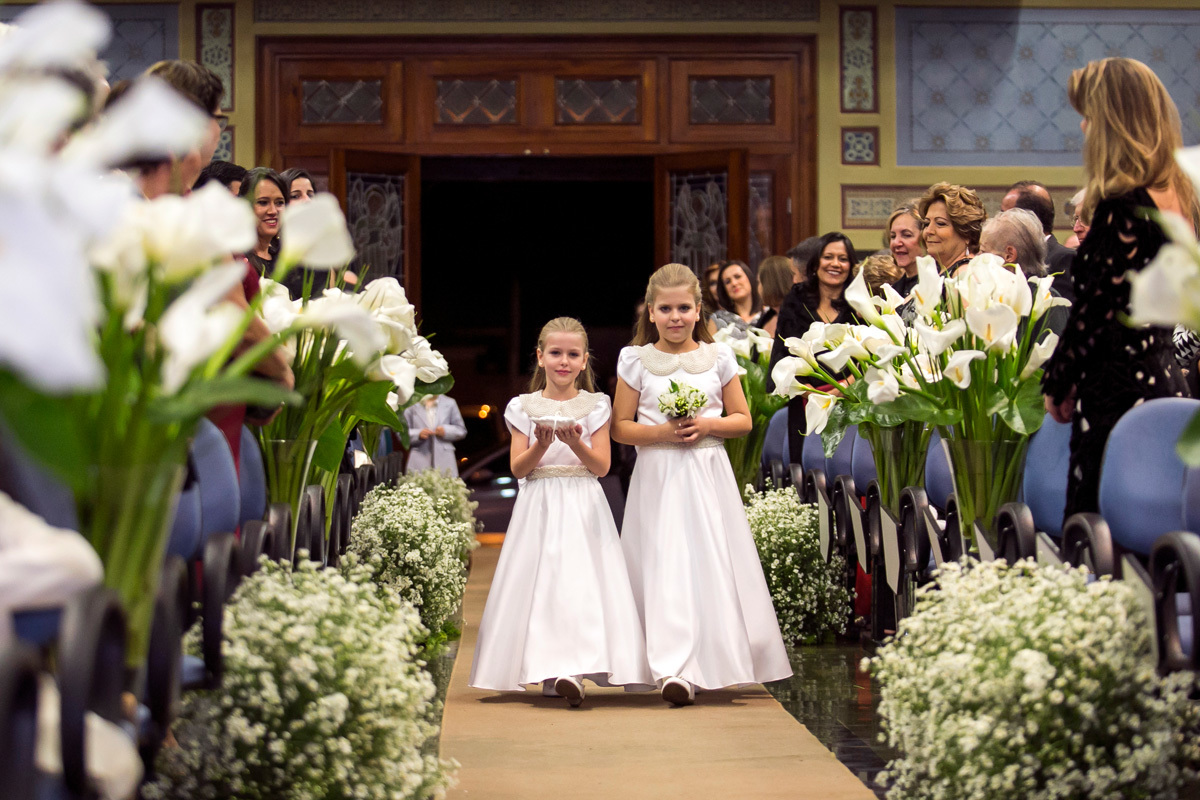 Daminha de honra entrando no casamento com as alianças.