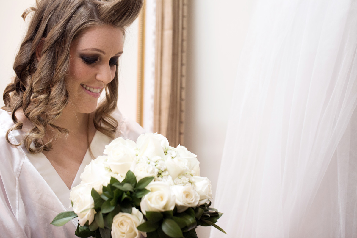 Noiva olhando para seu buque no make up realizado no L'eclat centro de beleza