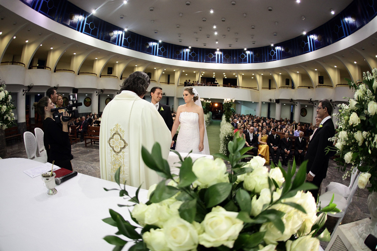 Noivos no altar com o buque encima da mesa da cerimônia
