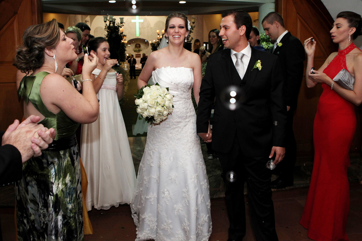 noivos saindo da cerimônia de casamento com bolinhas de sabão na igreja Estigmatinos em Ribeirão Preto - SP