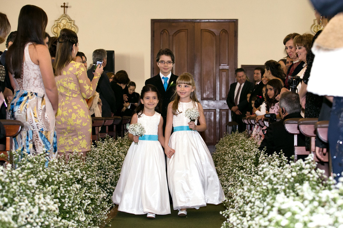 Dama de honra entrando na capela Estigmatinos toda florida para o casamento de Marcela e Renato