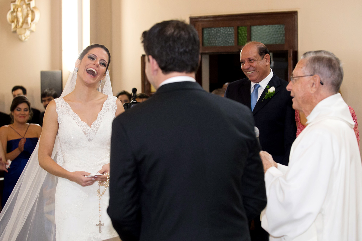 Noiva sorridente ao receber uma homenagem do noivo em um casamento em Ribeirão Preto na capela Estigmatinos