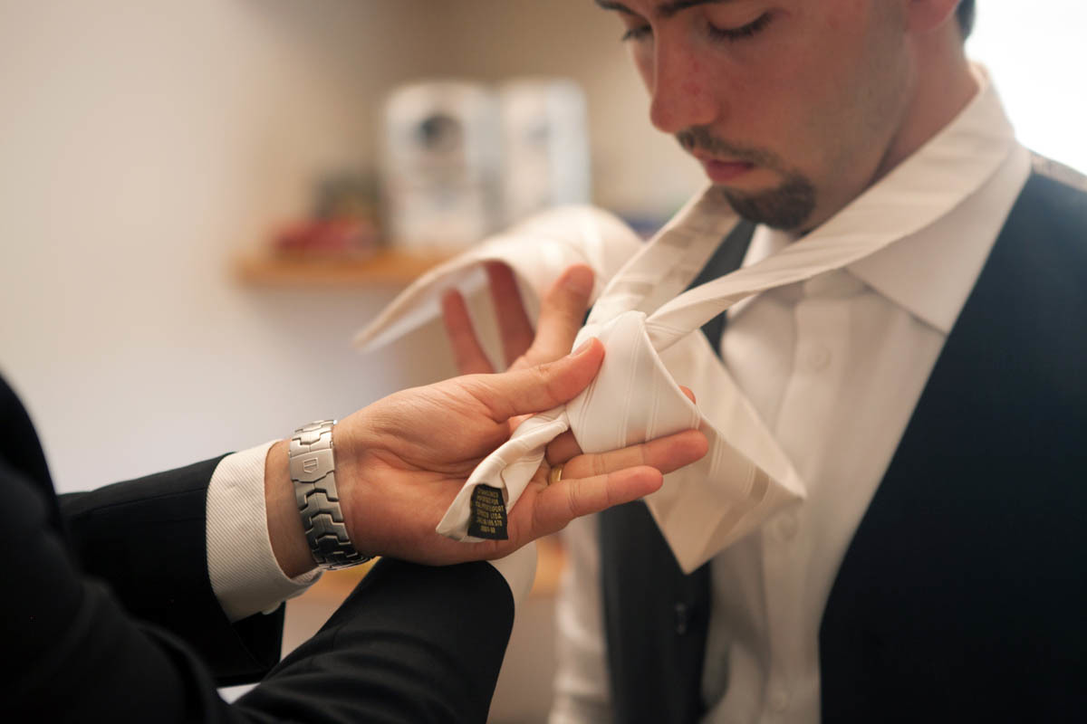 Irmão do Noivo ajudando seu irmão colocar a gravata em seu making of