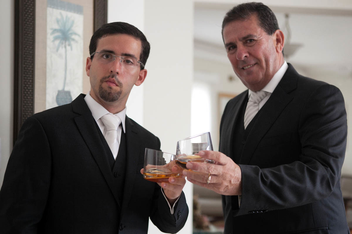 noivo brindando com seu pai antes de sair para seu casamento.
