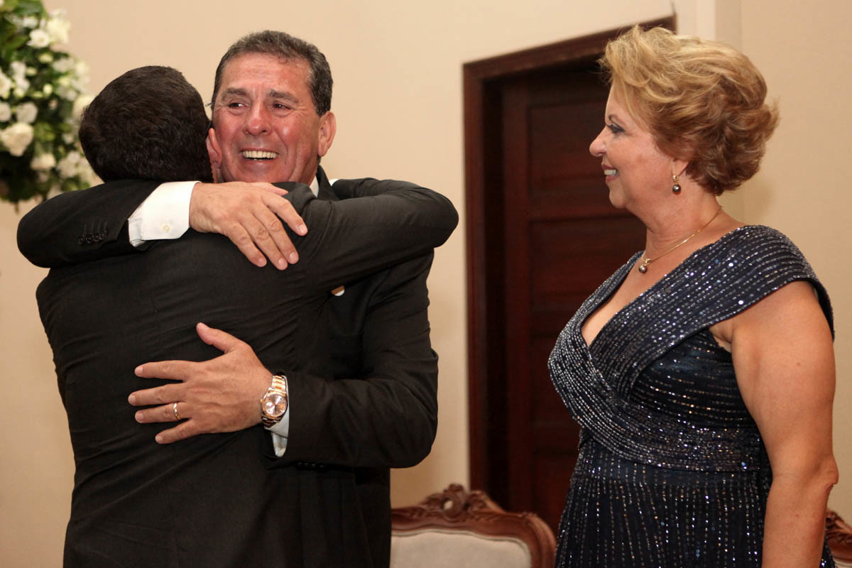 Sorriso do pai do noivo ao abraçar o recém casado na igreja