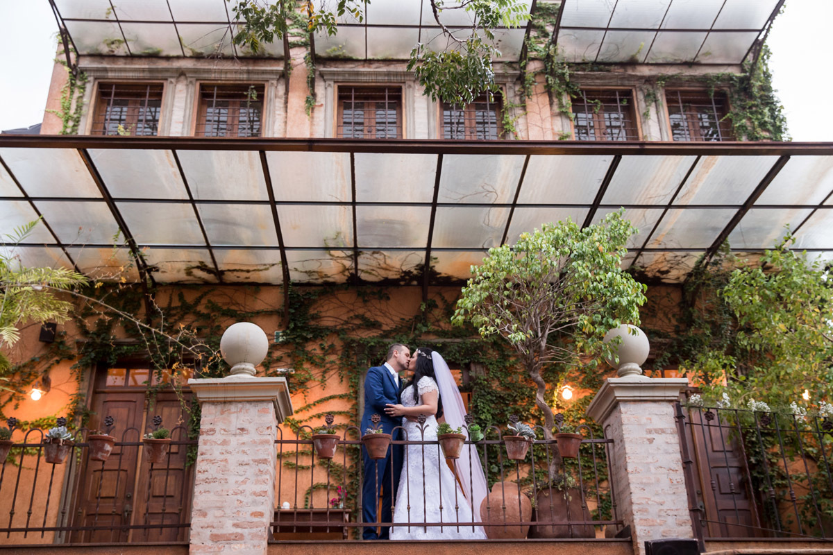 imagem dos noivos se beijando na sacada do restaurante Amici