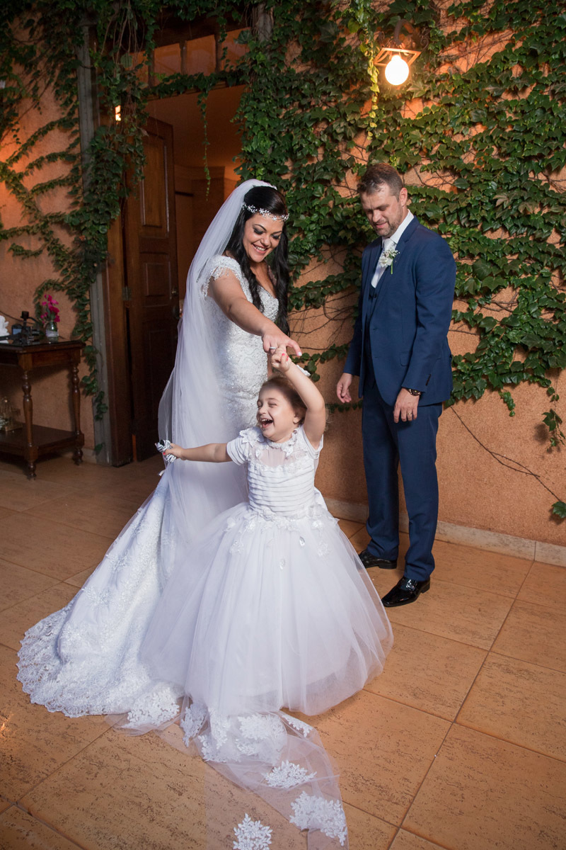 noivos brincam com sua filha no casamento