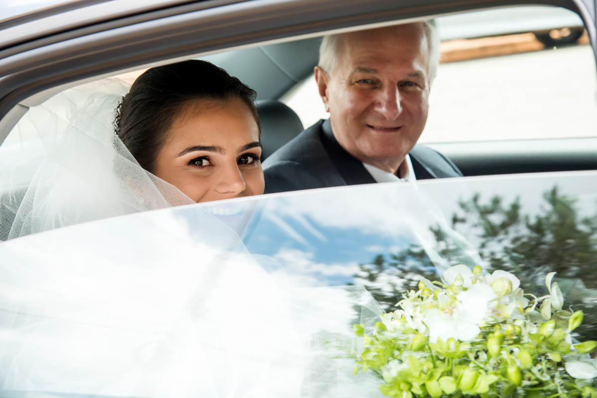 linda noiva aguardando para entrar na igreja com seu pai.