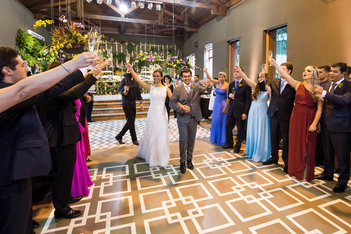 Noivos chegando na festa e brindando com os convidados