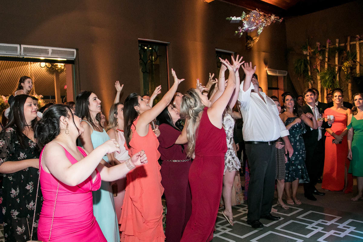 Convidados pulando para pegar o buque