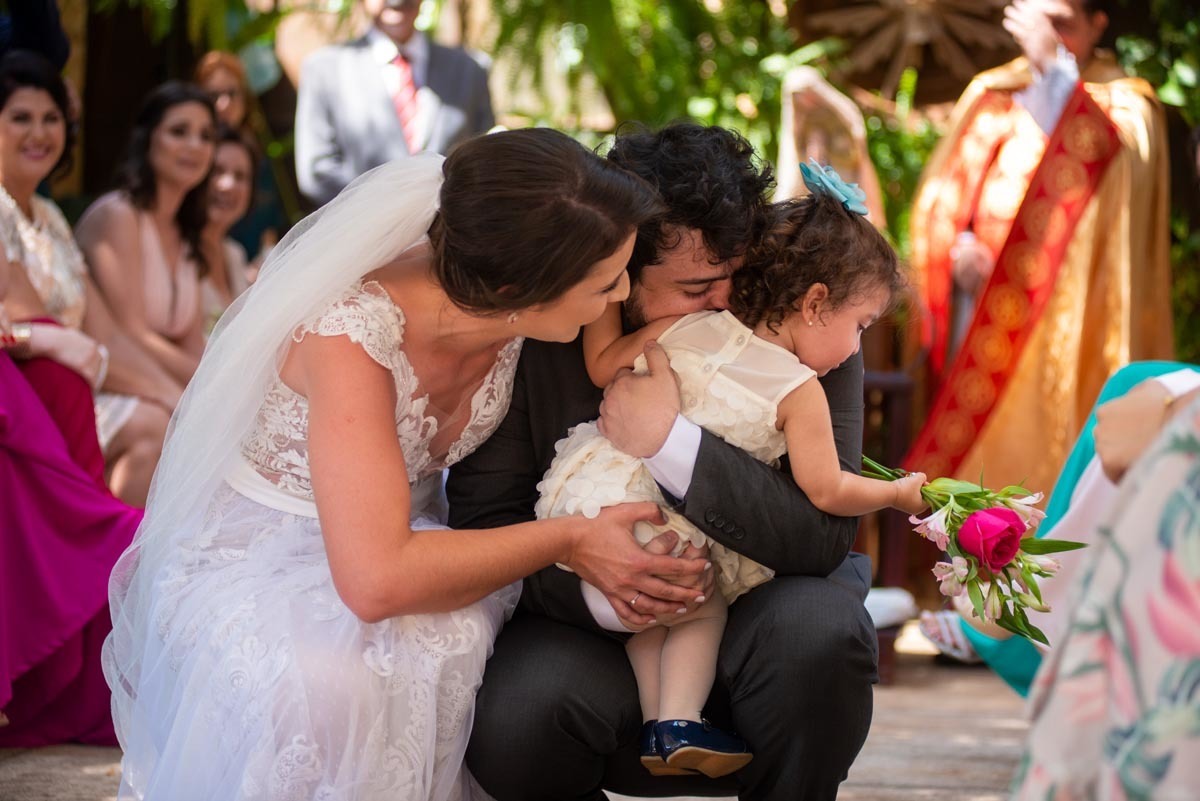 noivos emocionados ao receber as alianças de sua filha