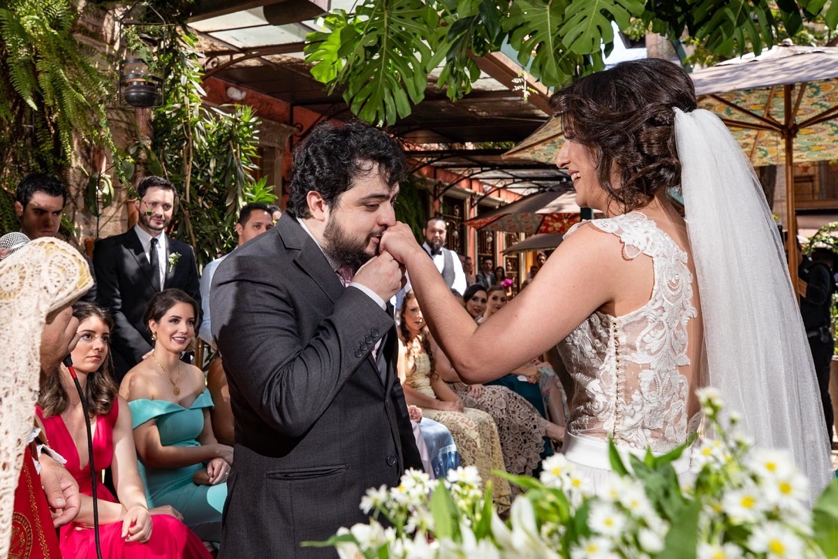  noivo beija a aliança da noiva no casamento de dia realizado no Ristorante Amici em Ribeirão Preto ´SP