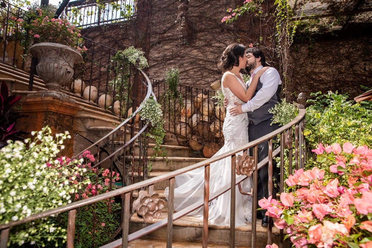 foto tradicional dos noivos se beijando na escada do Amici Ristorante em Ribeirão Preto.
