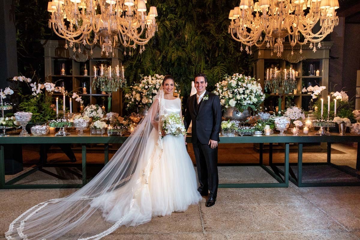 noivos em frente da mesa do bolo no casamento de Carolina e Gustavo Sanches