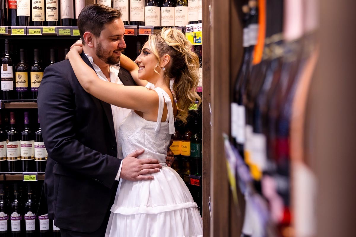 noivos em ensaio pre wedding na seção de vinhos do supermercado Mialich