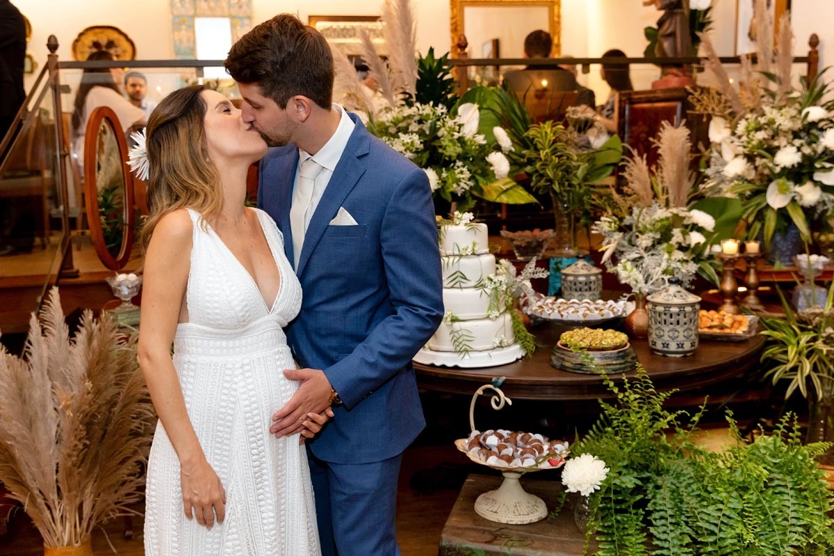 beijo dos noivos na mesa do bolo