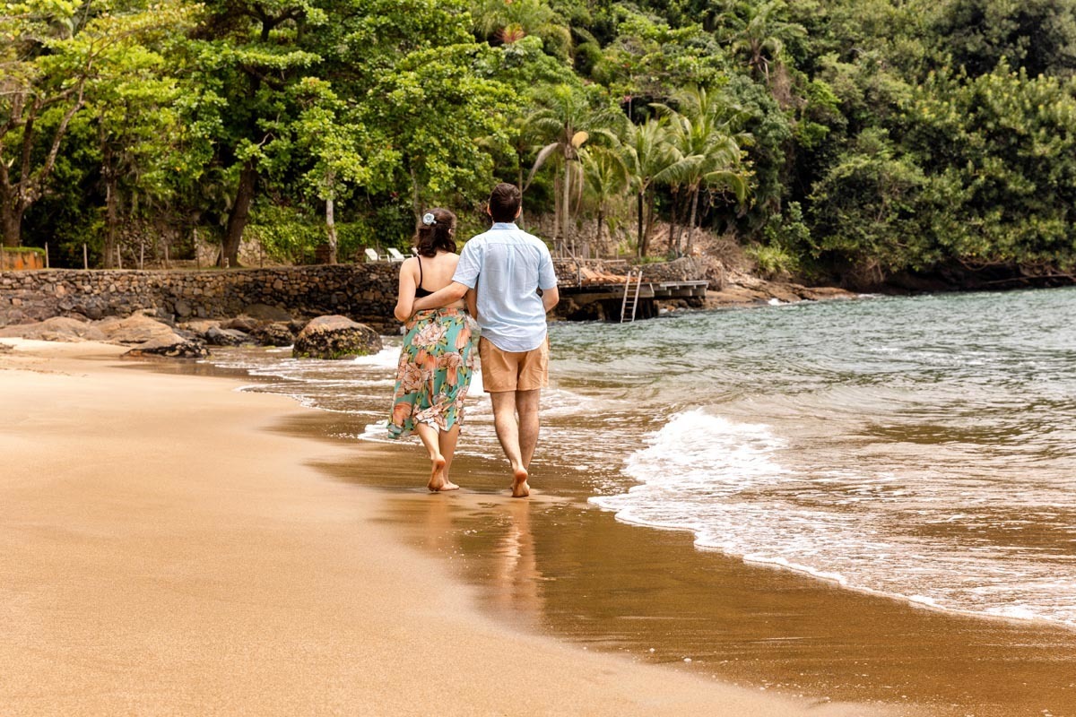 casal caminhando na areia da praia