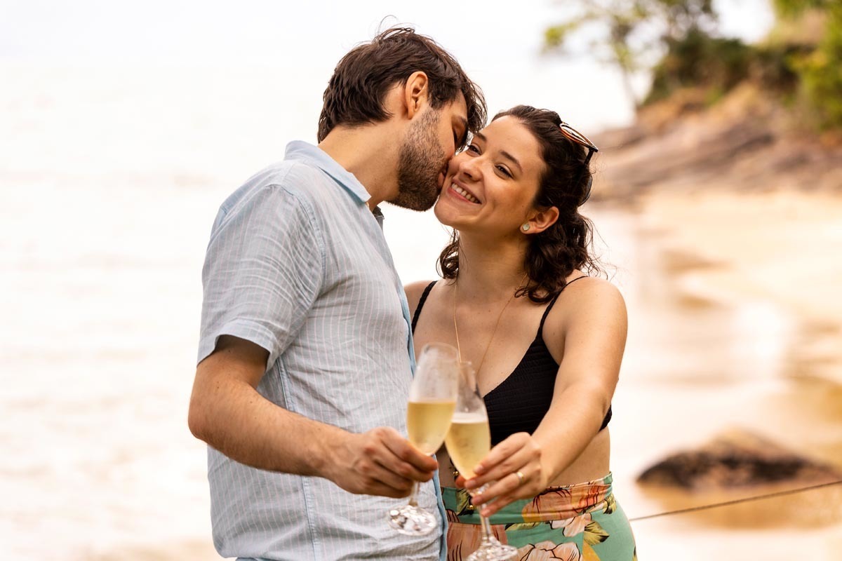 casal brindando na praia em ensaio fotografico na praia litoral de sao paulo