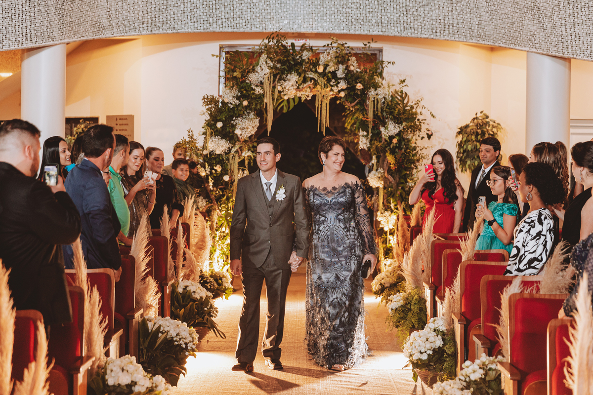 fotos de noivo com terno cinza escuro entrando no casamento 