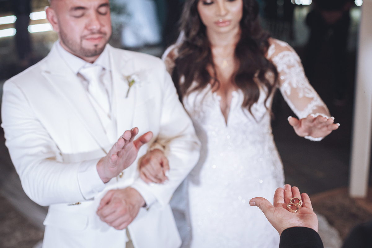 fotos de noivos orando sobre as alianças em cerimonia