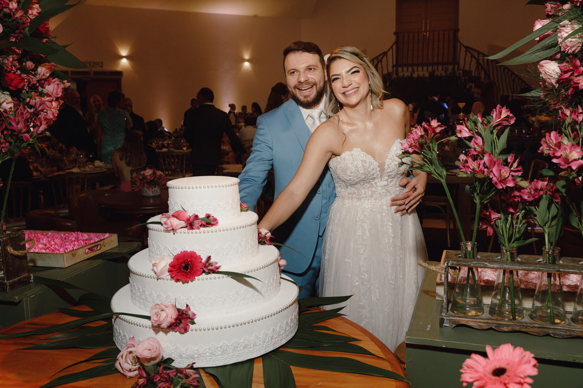 noivos com bolo na festa decoração estilo Boho flores rosas 