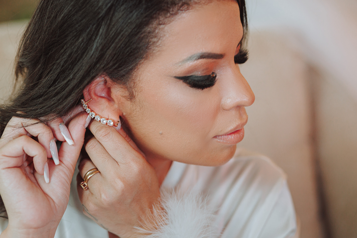 detalhes noiva se arrumando o making of colocando brinco inspiração de brinco para noivas maquiagem com delineado preto e cílios 