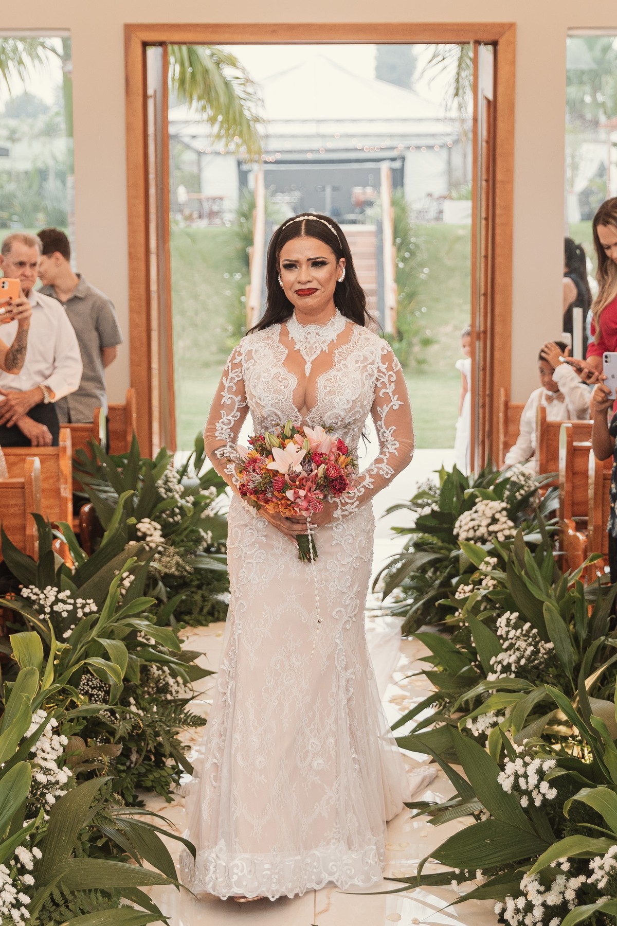 entrada emocionante de noiva na igreja capela inspiração de vestido sereia de manga longa e com bordado buquê alaranjado estilo boho chácara Lalinda Maringá e região