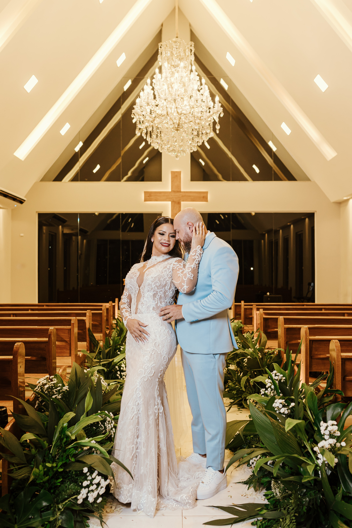 retratos dos noivos na capela da chácara Lalinda Maringá e região fotógrafo de casamentos noivo de terno azul claro e noiva de vestido sereia bordado manga longa