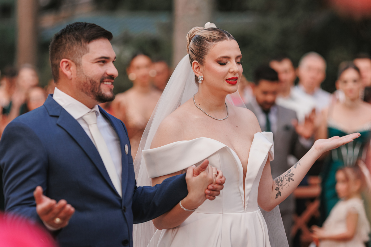 momento da oração em cerimonia de casamento externa em maringá noiva com vestido manga caida enoivo de terno azul