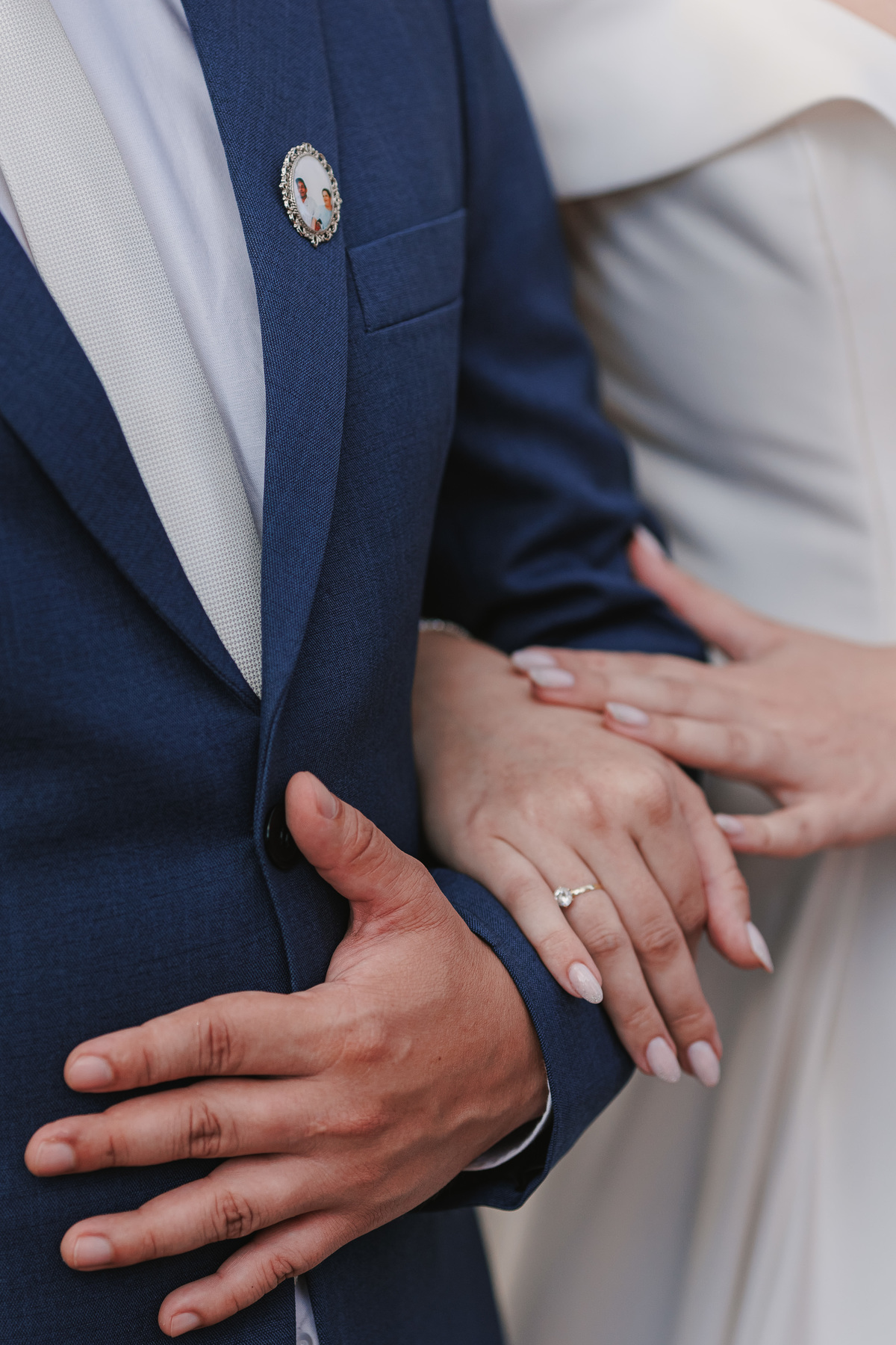 foto de detalhe durante cerimonia de casamento, noivos abraçados 