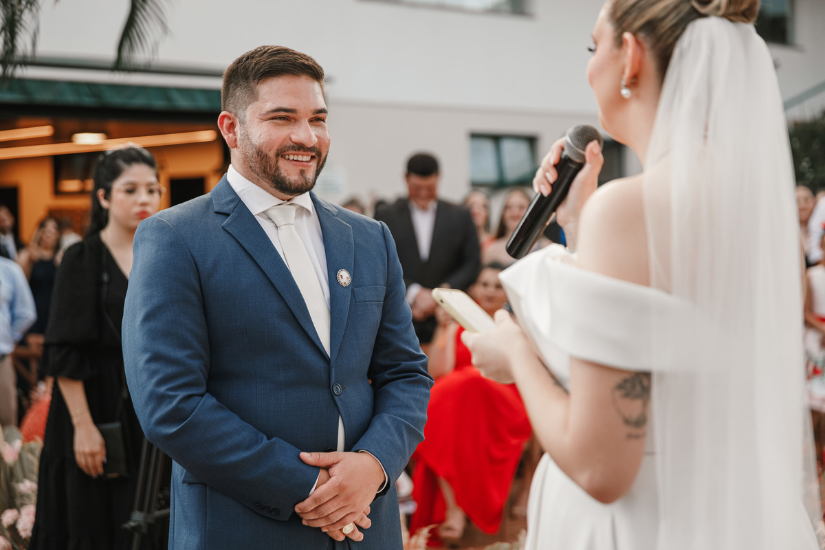 retrato espontâneo dos noivos sorrindo durante os votos em cerimônia de casamento externa  fotógrafo maringá