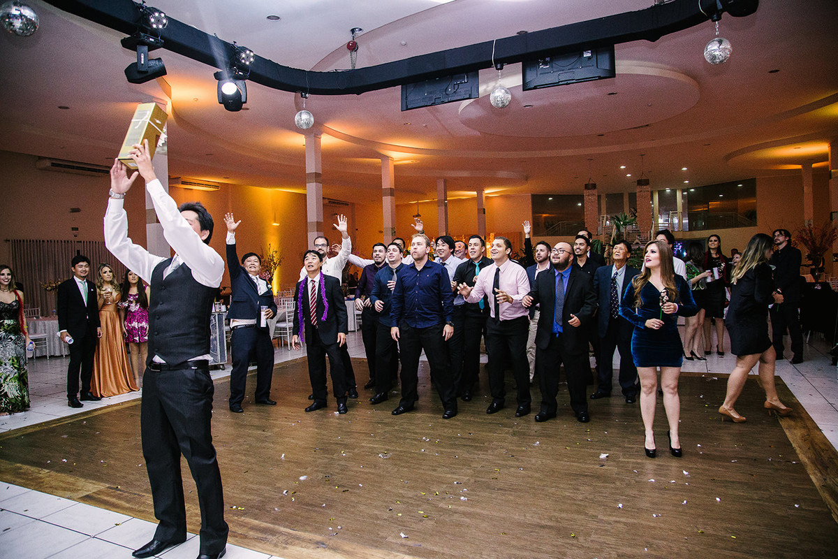 Foto do noivo jogando garrafa de bebida para convidados