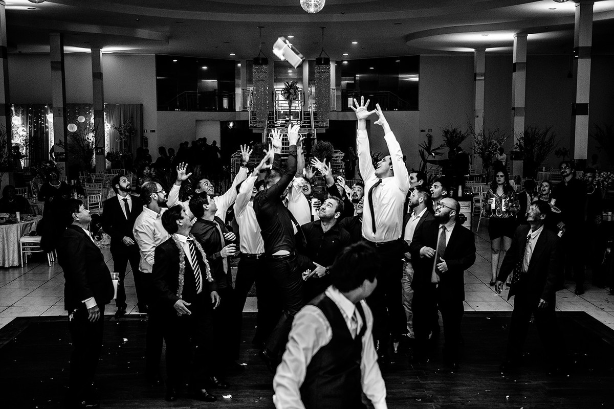 Momento do noivo jagando garrafa de wisky para convidados