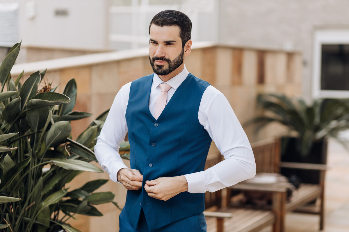 Noivo ajustando seu colete azul no durante fotos do making of do noivo 