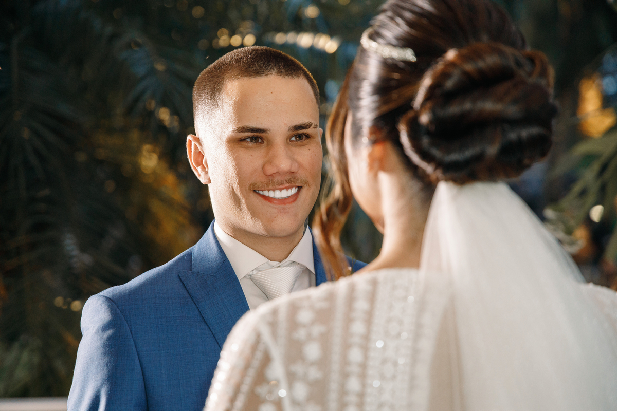 Noivo com terno azul marinho e penteado da noiva no casamento ao ar livre