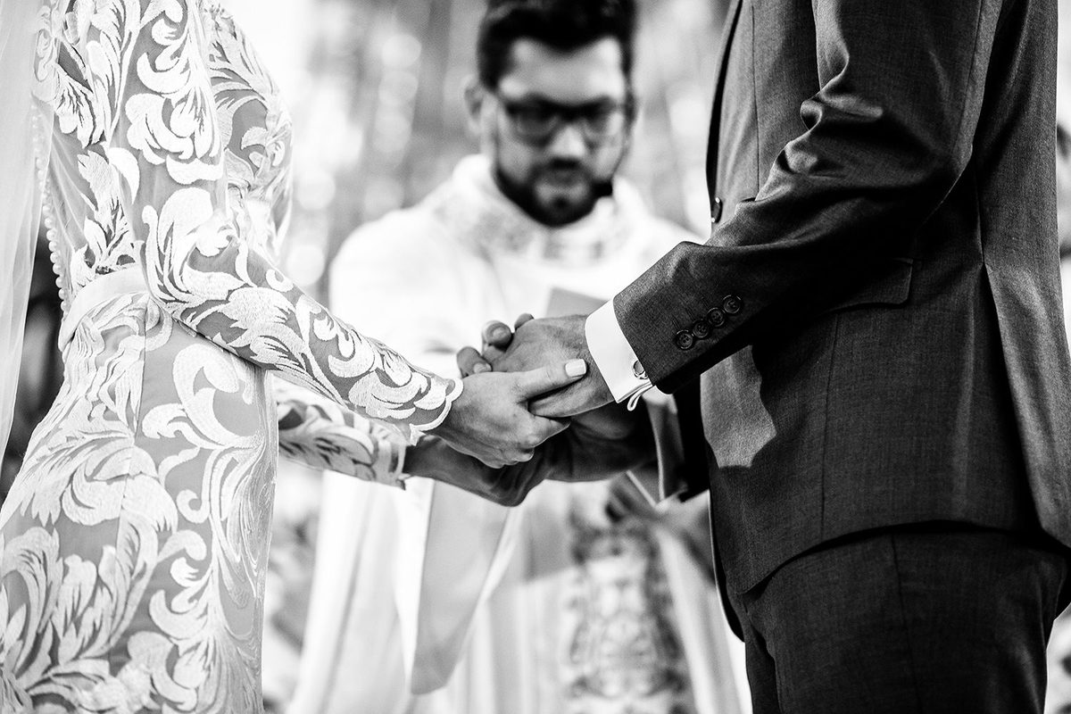 Noivos de mãos dadas durante cerimonia de casamento 