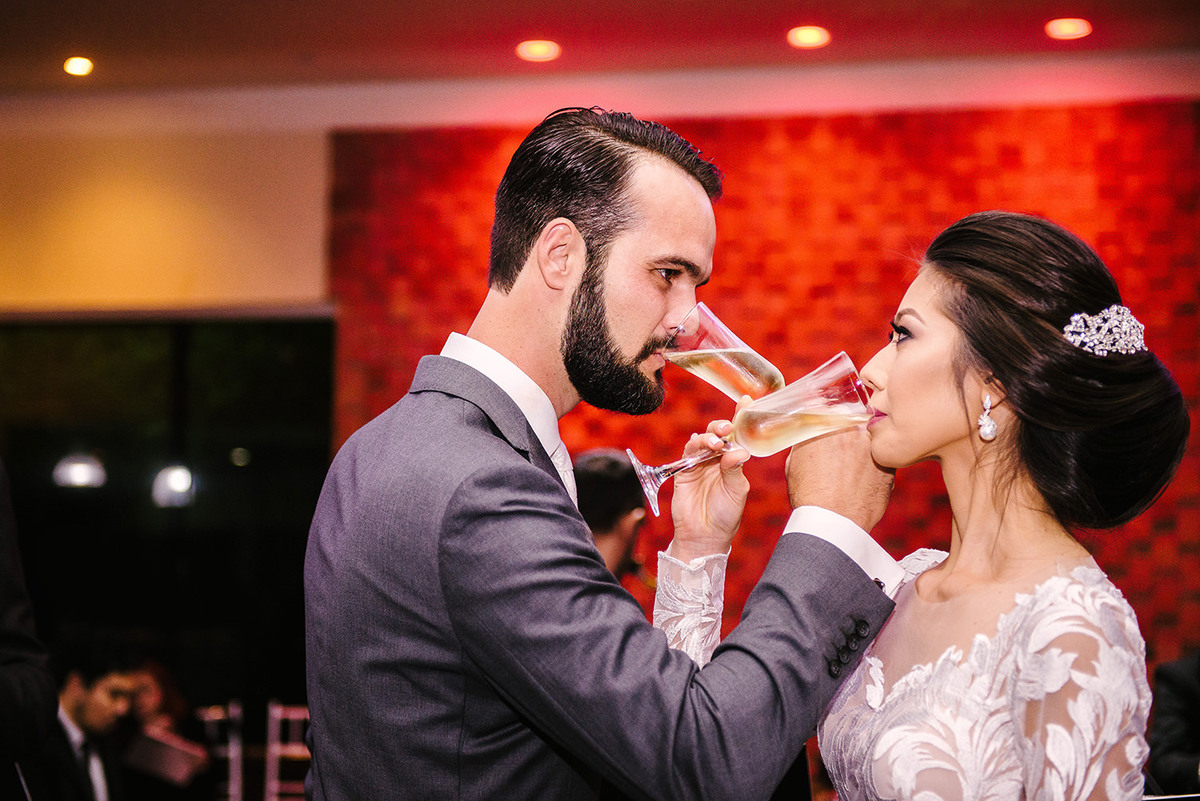 Noivos tomando champnhe durante o casamento 