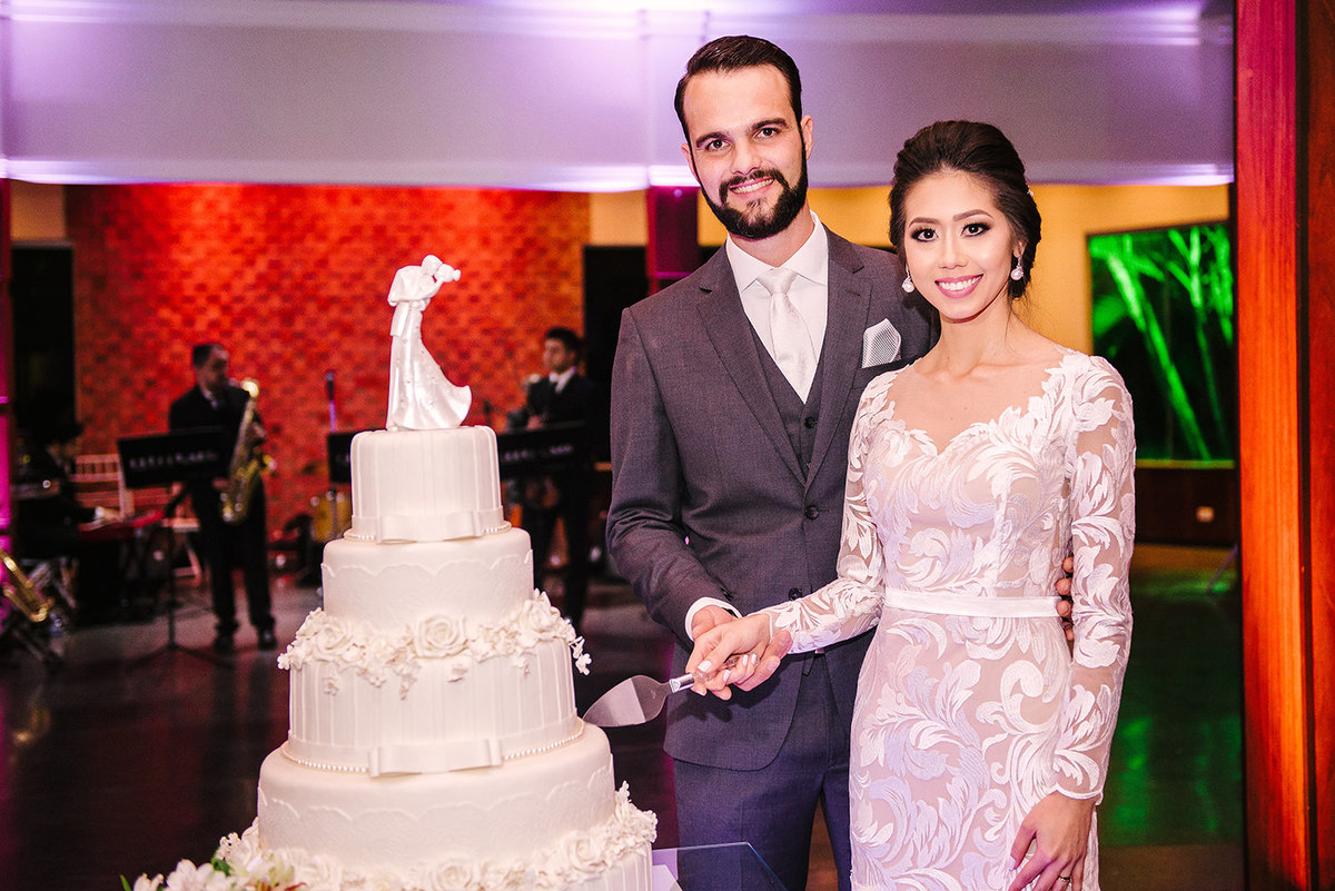 Foto de casamento dos noivos com o bolo e casamento 