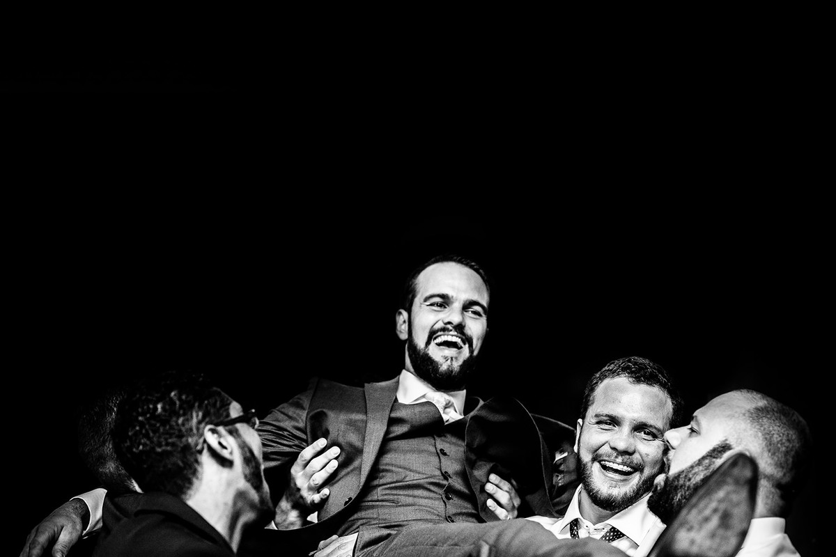 Foto dos amigos jogando o noivo pro alto