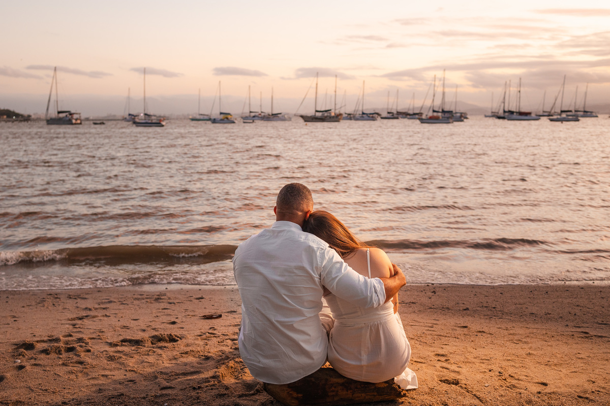 Ensaio pré-casamento na praia com o mar ao fundo
