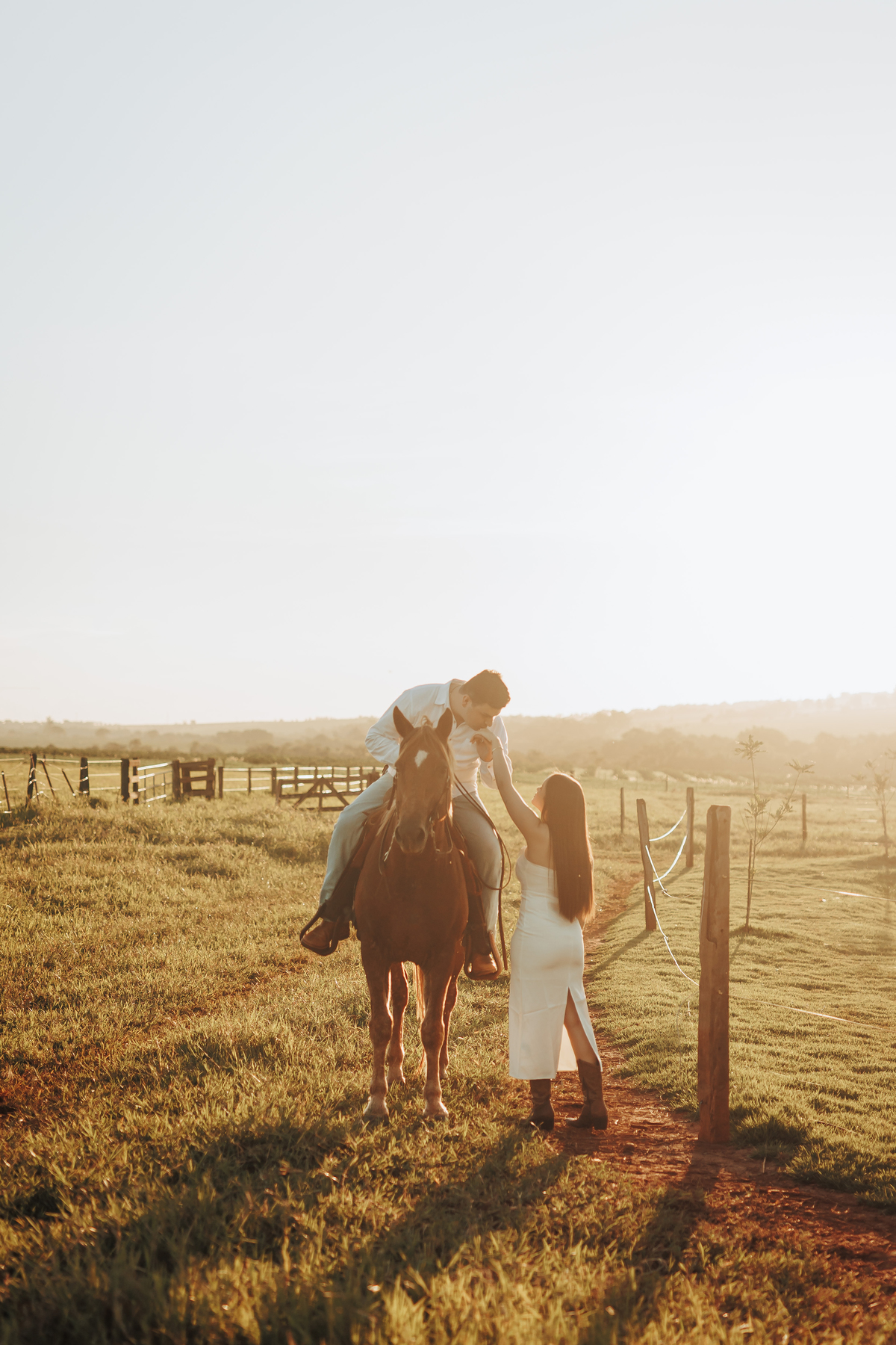 Ensaio de casal em fazenda durante o pôr do sol