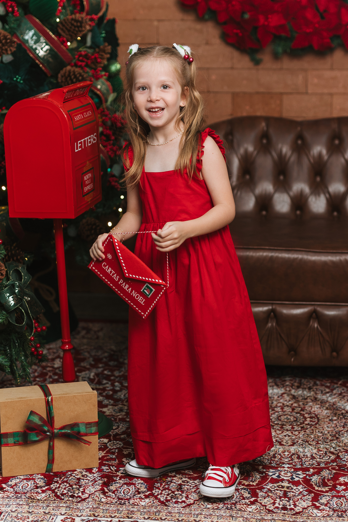 Foto infantil de Natal com vestido vermelho em Maringá.