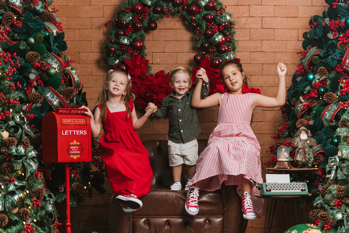 Ensaio de Natal em família em Maringá com crianças no cenário natalino.